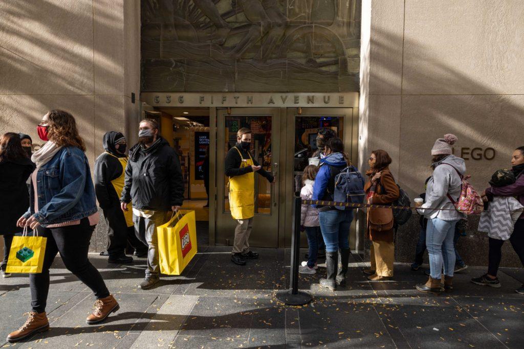 People carrying shopping bags walk out from a Lego store in New York on Black Friday, Nov 26. Deaths are averaging 1,700 per day, up from about 1,400 in recent days but within levels seen earlier this winter. Photo: AFP