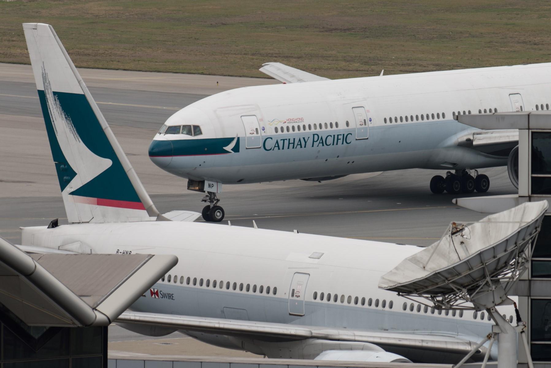 This file photo taken on March 15, 2017 shows a Cathay Pacific Boeing 777 passenger aircraft (top) taxiing past a stationary plane on the tarmac at the international airport in Hong Kong. Photo: AFP