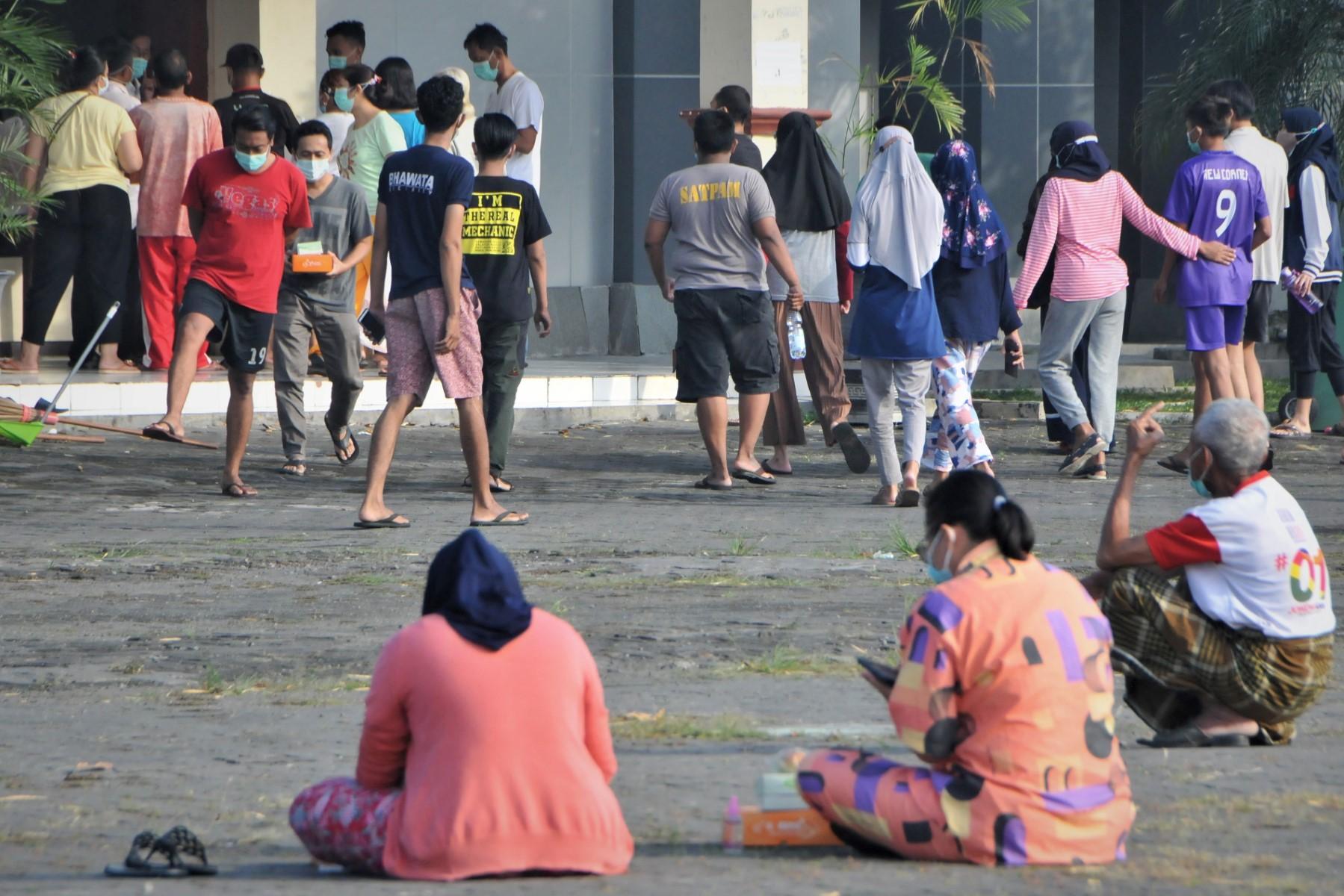 People tested positive for the Covid-19 get some morning sun in the courtyard of an isolation centre in Boyolali, Central Java on July 16, 2021. Photo: AFP
