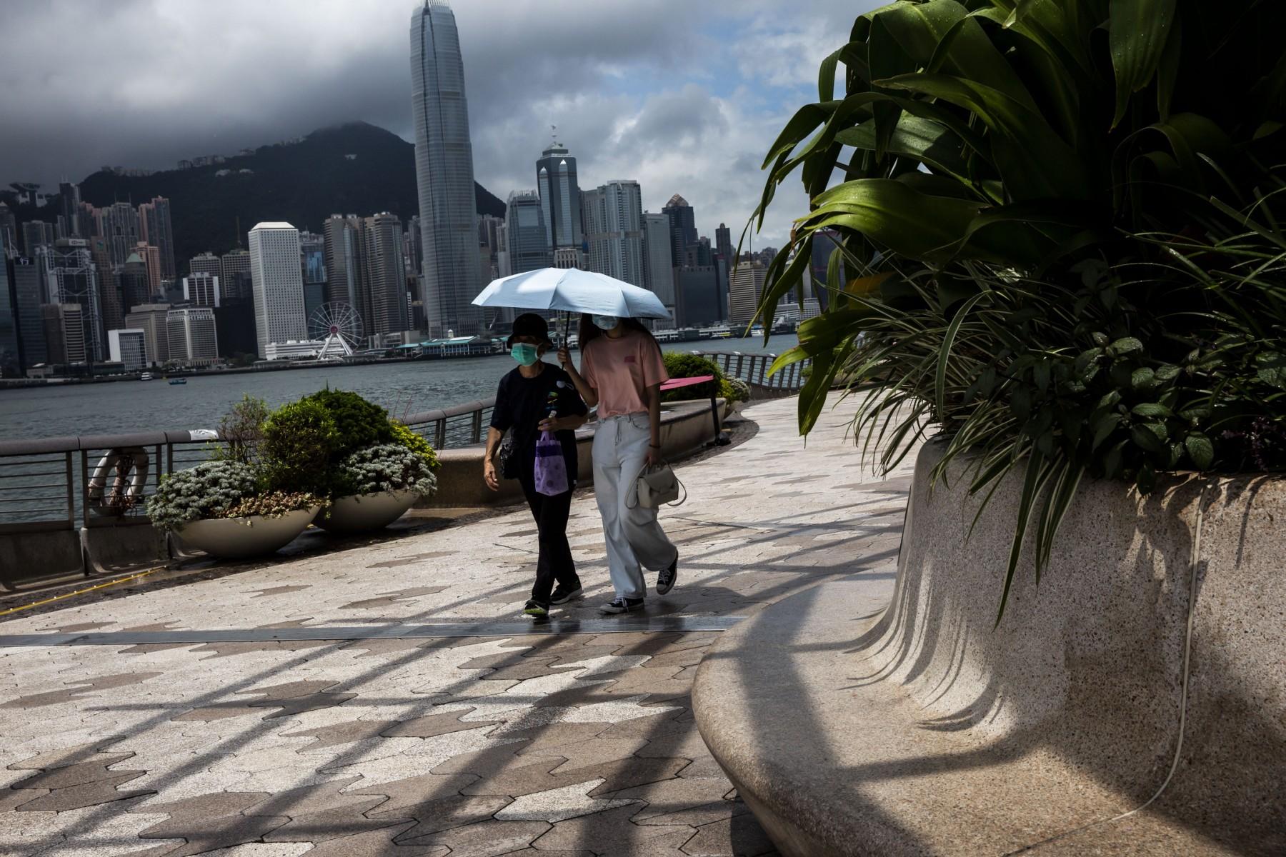 Two women walk along Victoria Harbour in the Kowloon district of Hong Kong on Aug 16, 2021. Photo: AFP