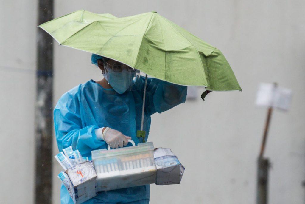 A health worker wearing personal protective equipment holds an umbrella as she carries medical supplies, at St Ana Hospital, in Manila, Philippines, Sept 8, 2021. Photo: Reuters