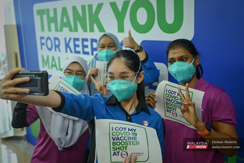 Health workers pose for a photo after completing their third dose of Pfizer vaccine at KPJ Tawakkal in Jalan Pahang, Kuala Lumpur.