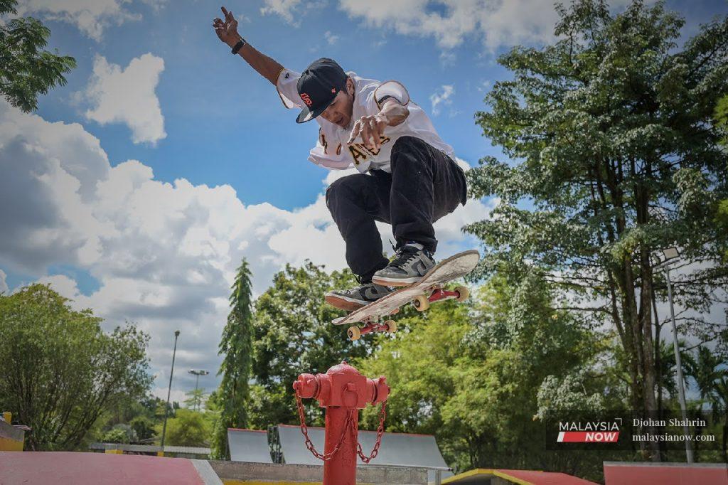 Denny Zulfikar menunjukkan satu aksi bermain papan selaju di Kuching School of Skateboarding, Sarawak.
