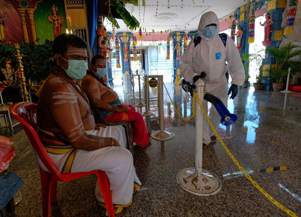 A temple worker sprays sanitiser at the Kallumal Arulmigu Subramania temple in Gunung Cheroh, Ipoh, ahead of Thaipusam celebrations today. Photo: Bernama