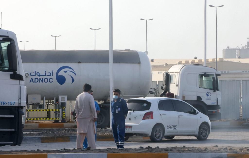 Men stand outside a storage facility of oil giant Adnoc in the capital of the United Arab Emirates, Abu Dhabi, on Jan 17. Three people were killed in a suspected drone attack that set off a blast and a fire in Abu Dhabi today, officials said, as Yemen's rebels announced military operations in the United Arab Emirates. Photo: AFP