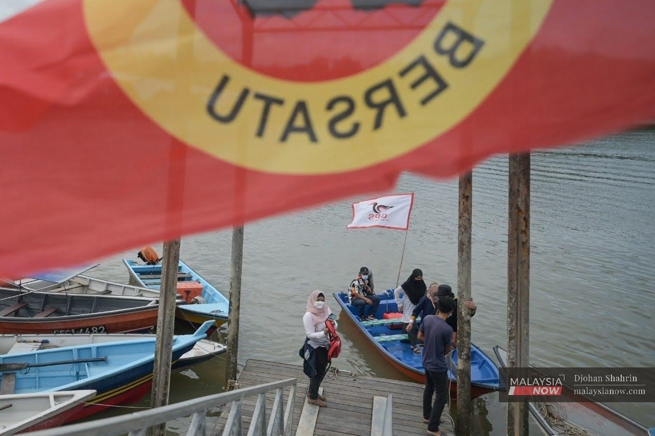 A Parti Rakyat Sarawak flag flutters in the breeze at the jetty in Pulau Salak as voters disembark from boats to cast their ballots in the recent state election.