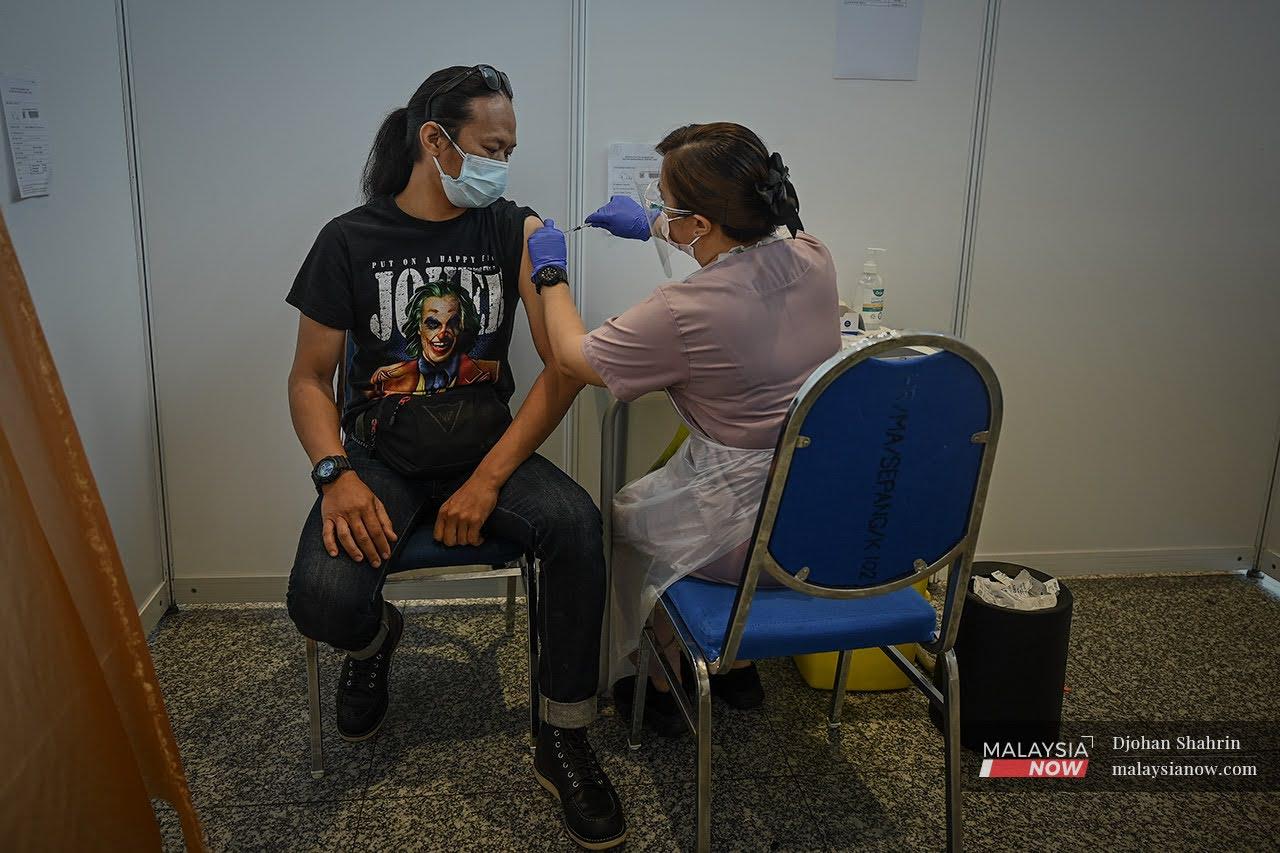 Petugas kesihatan menjalankan vaksinasi dos kedua di KLIA, Sepang.
