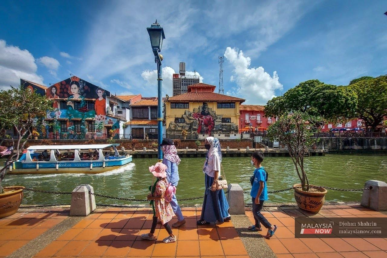 Pengunjung menikmati keindahan di sepanjang Sungai Melaka berhampiran Jonker Street dengan memakai pelitup muka bagi melindungi diri daripada wabak Covid-19.