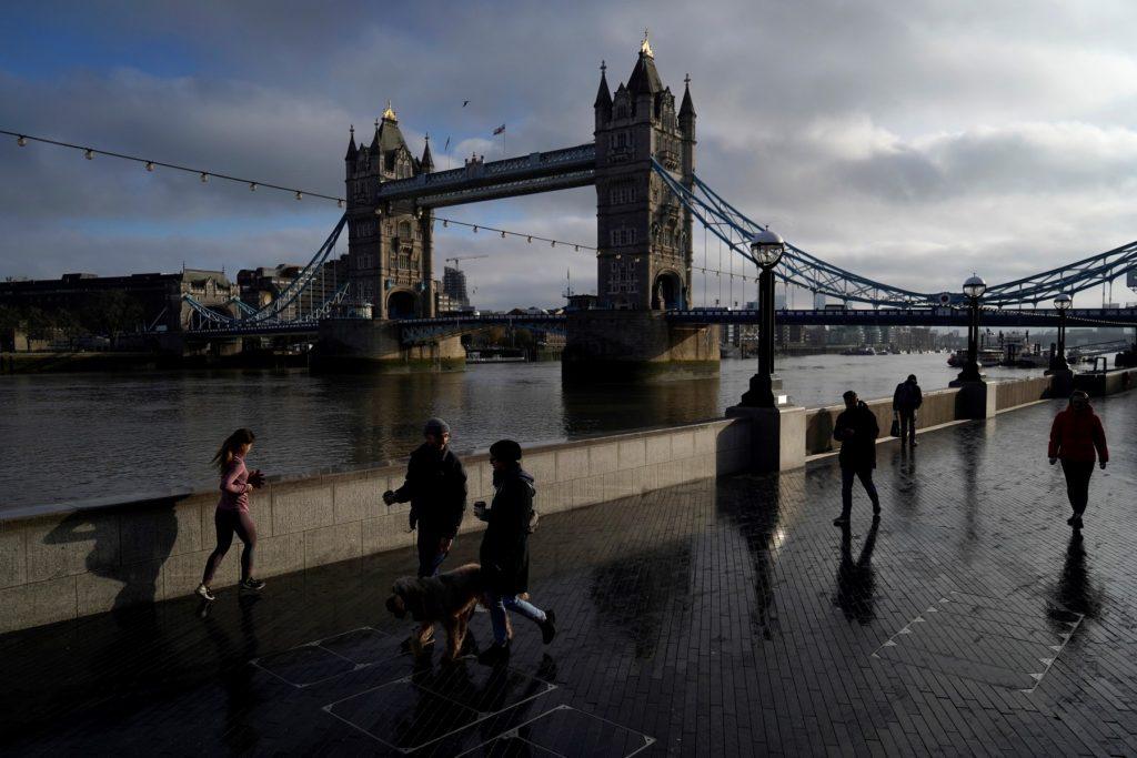People take their daily exercise along the Thames river embankment near the Tower Bridge in central London on Feb 4, 2021, during the third national lockdown. Photo: AFP