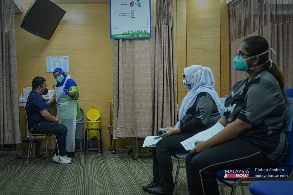 Health workers wait their turn to receive their booster shots against Covid-19 at the KPJ Tawakkal vaccination centre in Jalan Pahang, Kuala Lumpur.