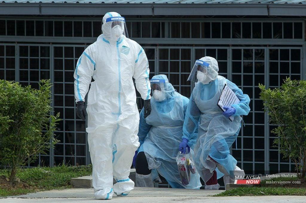 Petugas kesihatan memakai pakaian pelindung lengkap ketika menjalankan ujian saringan Covid-19.