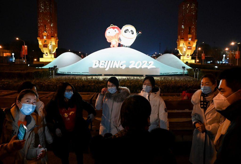 People are seen in front of an installation displaying respective mascots of the 2022 Beijing Winter Olympic and Paralympic Games, along a street in Beijing on Jan 19. Photo: AFP