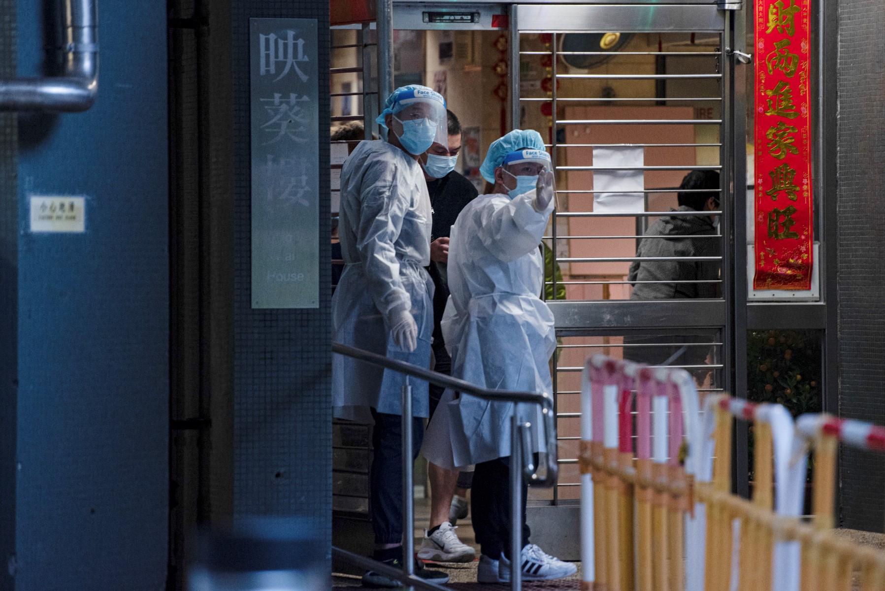 Health workers guide residents outside a building placed under lockdown at the Kwai Chung Estate public housing complex in Hong Kong on Jan 22, amid a rise in coronavirus cases fuelled by the Omicron variant. Photo: AFP