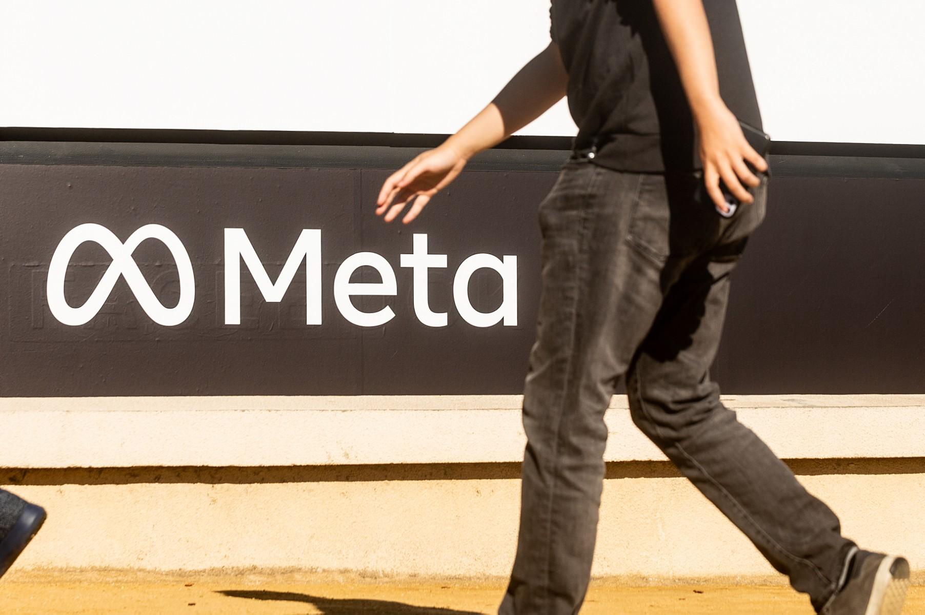A person walks past a newly unveiled logo for 'Meta', the new name for Facebook's parent company, outside Facebook headquarters in Menlo Park on Oct 28, 2021. The social media company changed its name in October to Meta to reflect its focus on the metaverse, which it thinks will be the successor to the mobile internet. Photo: AFP