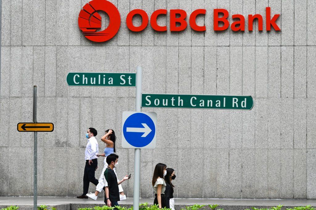 People walk past OCBC Bank during their lunch break at the Raffles Place financial business district in Singapore on Sept 14, 2021. Photo: AFP