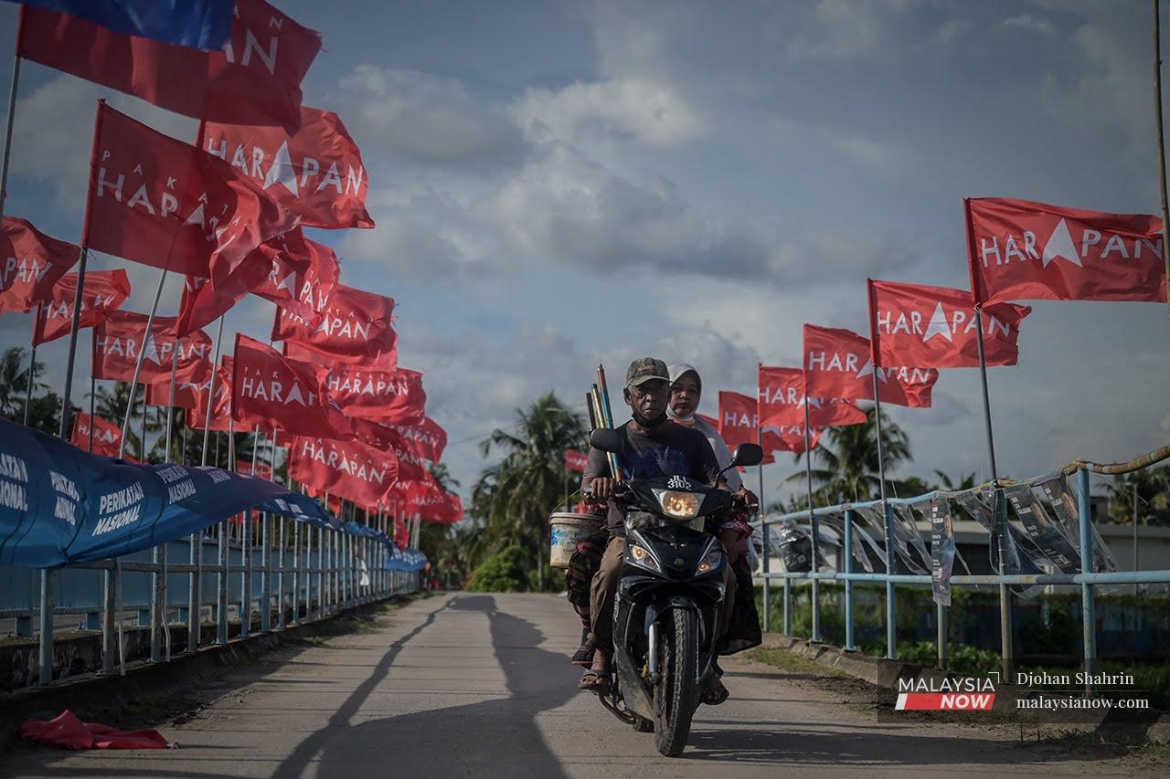 Motorcyclists cross a bridge festooned with the flags of Pakatan Harapan and Perikatan Nasional at Bukit Rambai, Melaka, ahead of the state polls held on Nov 20 last year.