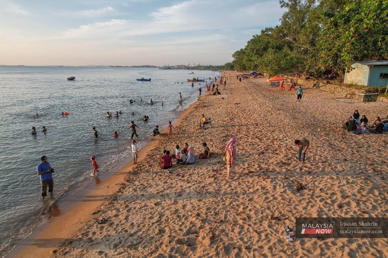 Beberapa pengunjung bersantai dengan ahli keluarga di pantai Pengkalan Balak, Tanjung Bidara.