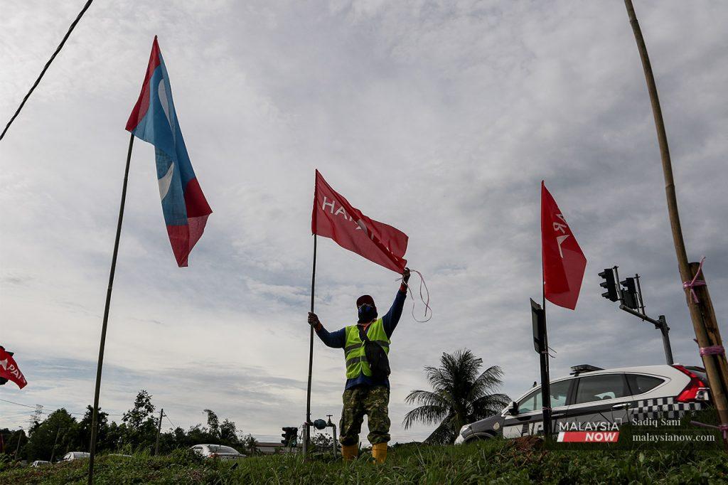 Seorang aktivis Pakatan Harapan mengibarkan bendera gabungan itu pada PRN Melaka tahun lalu.