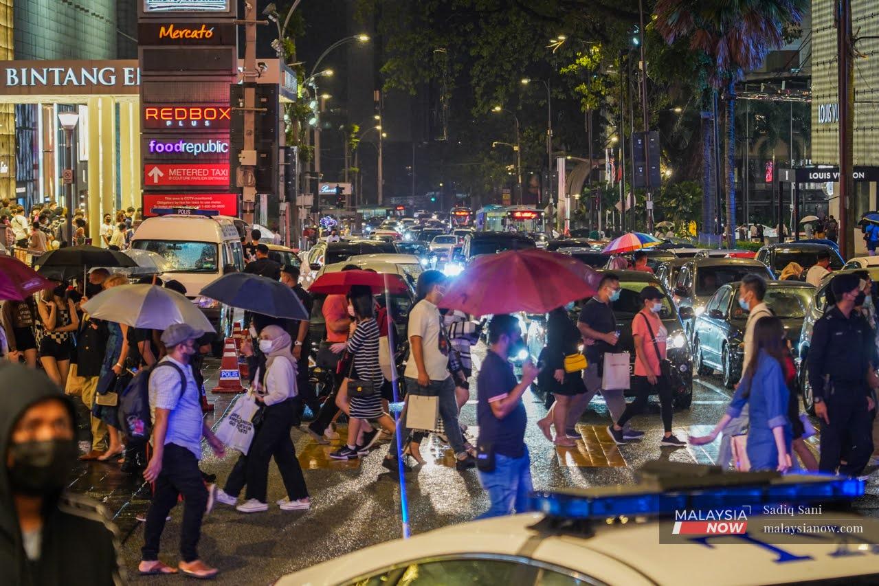 Pedestrians cross a road in the Bukit Bintang shopping district in Kuala Lumpur in this file picture.