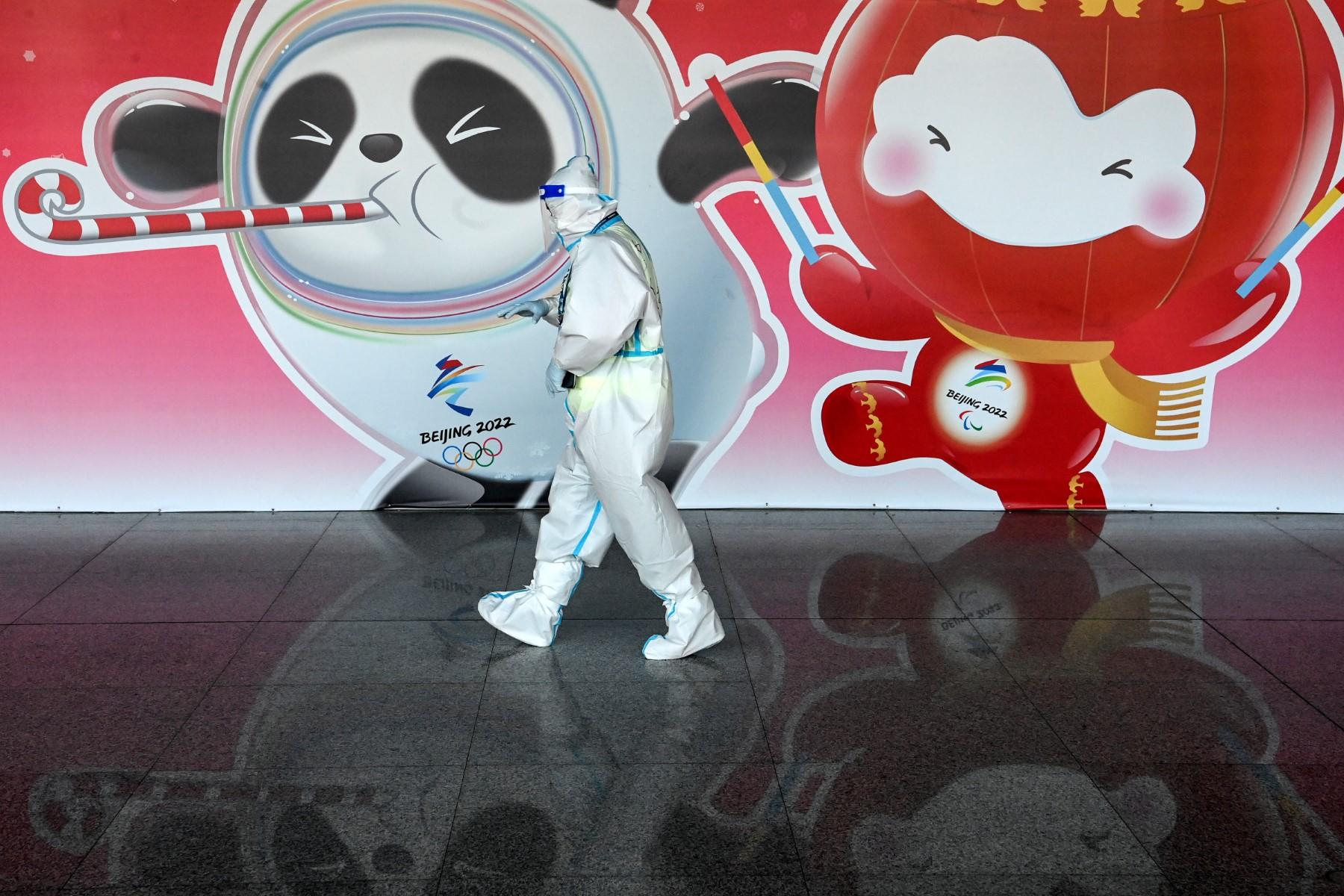 An employee wearing a hazmat suit walks past an Olympic mascot banner at the Beijing Capital International Airport ahead of the 2022 Winter Olympics in Beijing on Jan 27. Photo: AFP