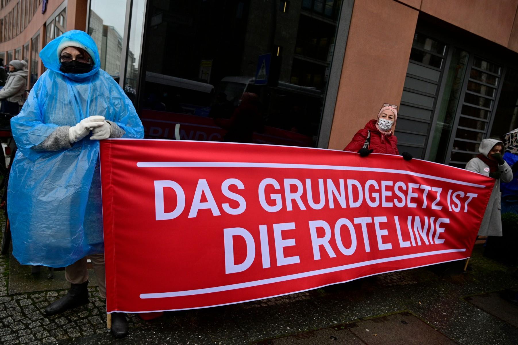 Anti-vaccine protesters hold a banner that reads 'The constitution is the red line' during a demonstration on Jan 26 in Berlin, while lawmakers debate plans to impose compulsory Covid-19 vaccinations. Photo: AFP