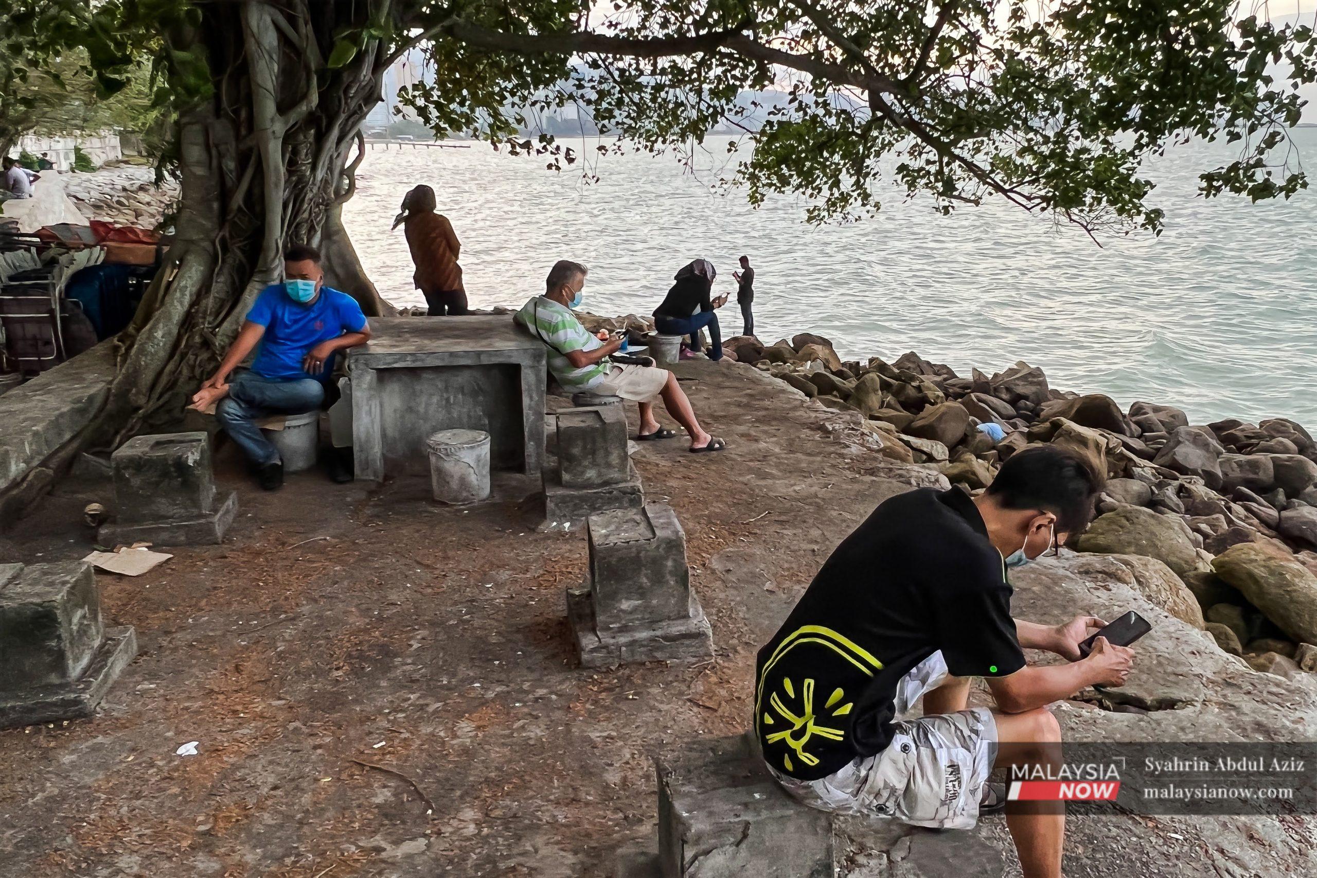 Oranf ramai menikmati pemandangan di tepi pantai Padang Kota Lama, Pulau Pinang.