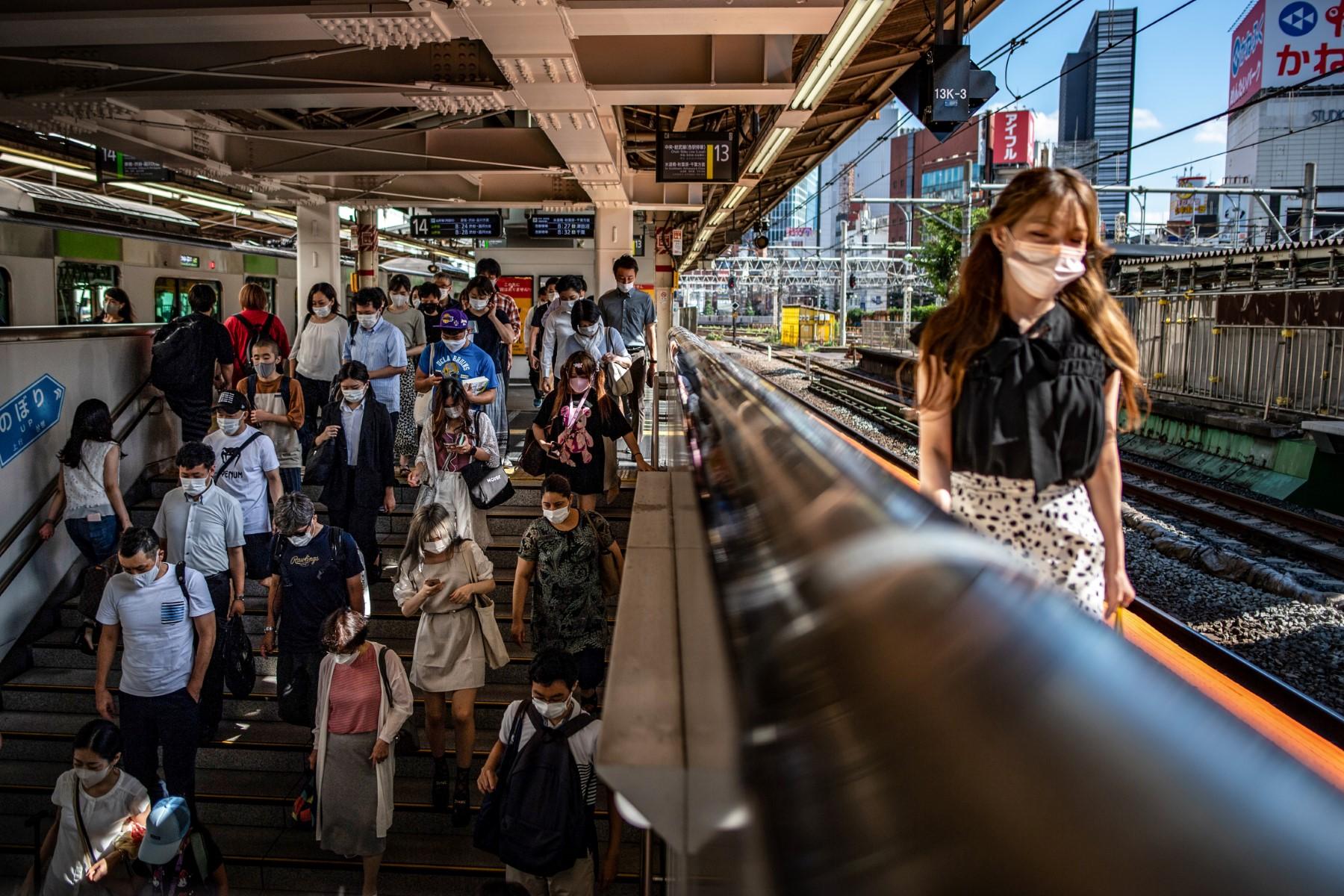 People walk in Shinjuku station of Tokyo on July 22, 2021. Photo: AFP