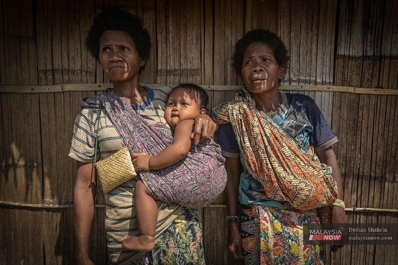 Two women from the Batek Orang Asli tribe, one of whom carries her grandchild, at their village in Taman Negara Kuala Koh.