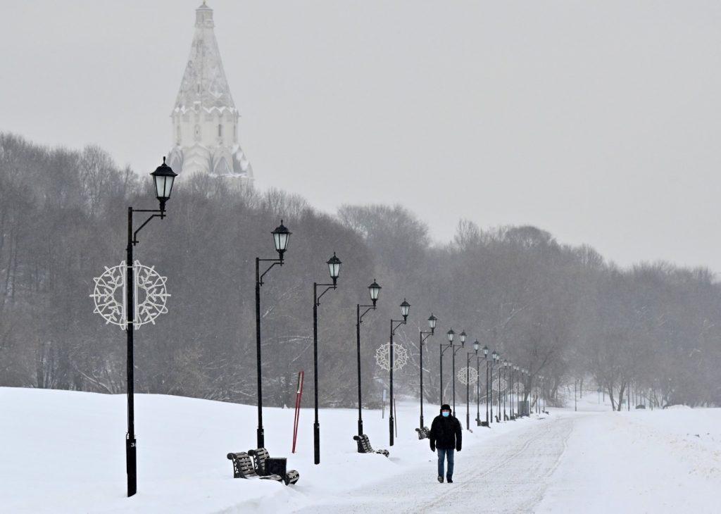 Seorang lelaki memakai pelitup muka berjalan di Kolomenskoye Park, di Moscow yang dipenuhi salji pada 21 Disember. Gambar: AFP