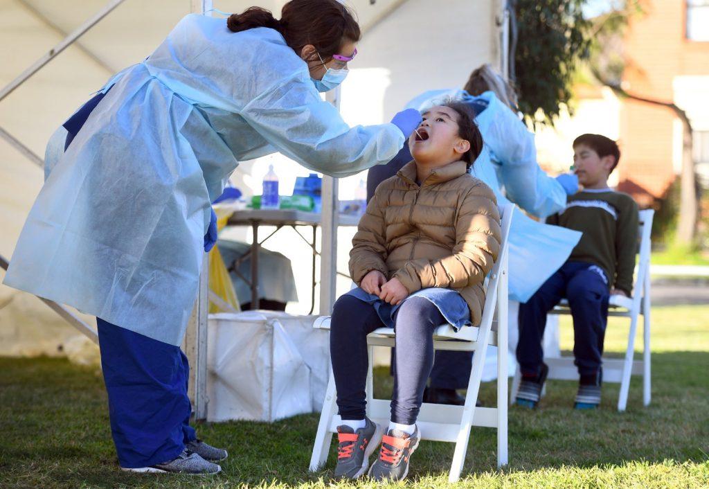 Children have a swab taken during testing for Covid-19 in a suburban park in Melbourne on July 1, 2020. Photo: AFP