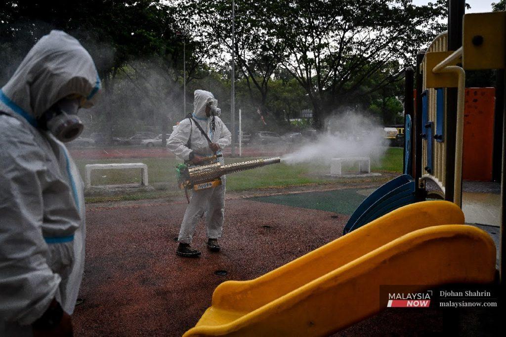 Sukarelawan melakukan aktiviti nyahkuman dan semburan nyamuk Aedes sekitar flat PPR Pudu Ulu, Kuala Lumpur.
