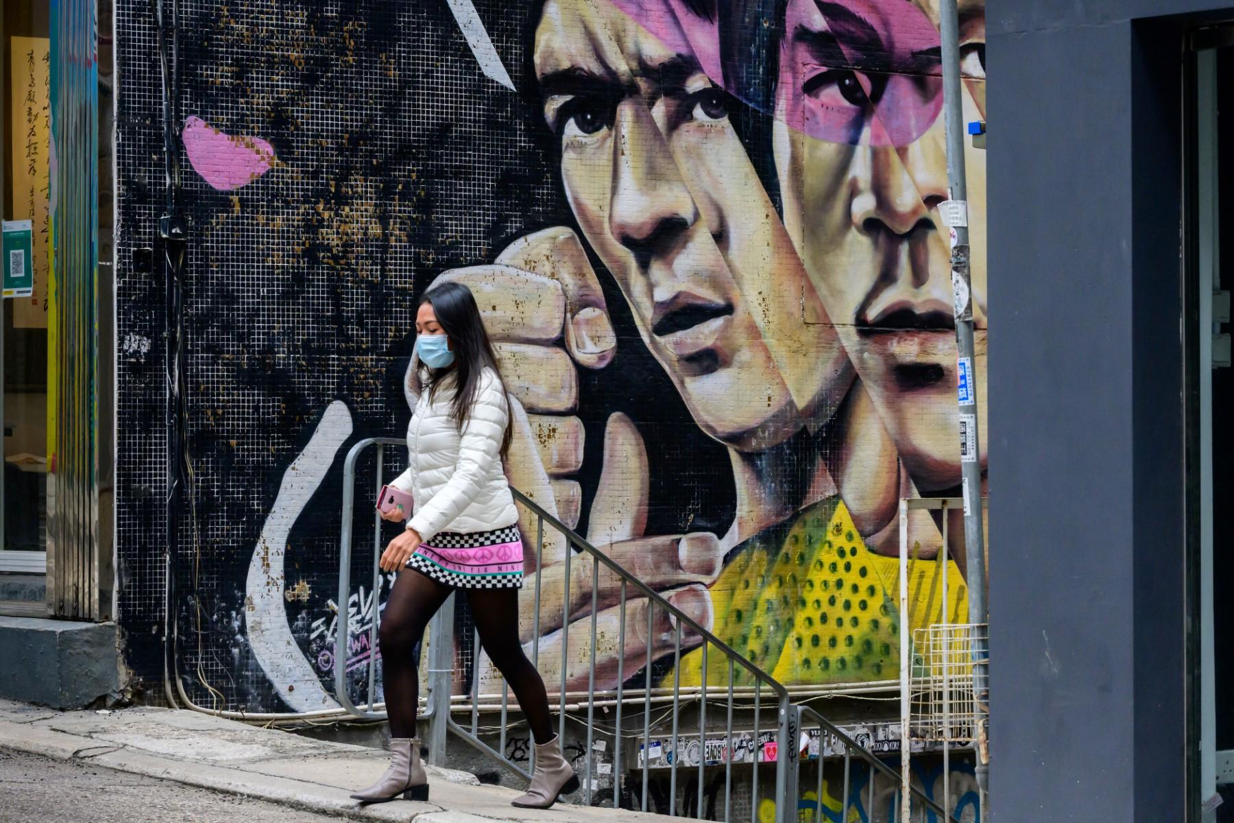 A woman walks in front of a mural depicting movie legend Bruce Lee in Hong Kong on Jan 30. Photo: AFP