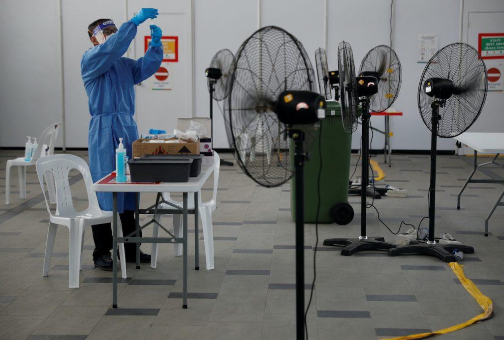 A health worker looks at a test kit at a quick test centre in Singapore, Sept 28, 2021. Photo: Reuters