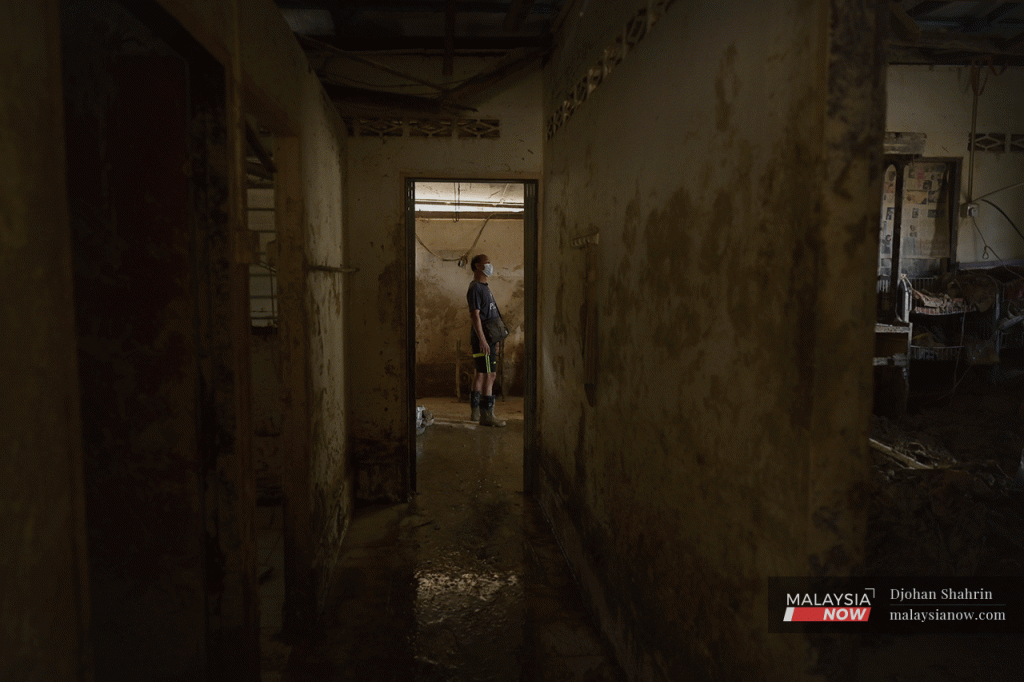 Mangsa banjir di Telemong, Ho Kai Yip memeriksa rumahnya yang masih jelas kelihatan ditenggelami air banjir walaupun beberapa kali mencuci tempat tinggalnya itu.