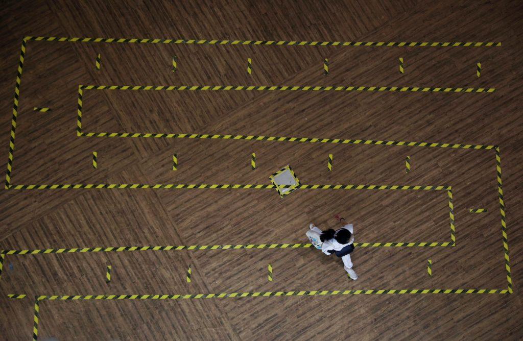 A woman walks across a line of tape demarcating social distancing in a mall in Singapore, Sept 28, 2021. Photo: Reuters