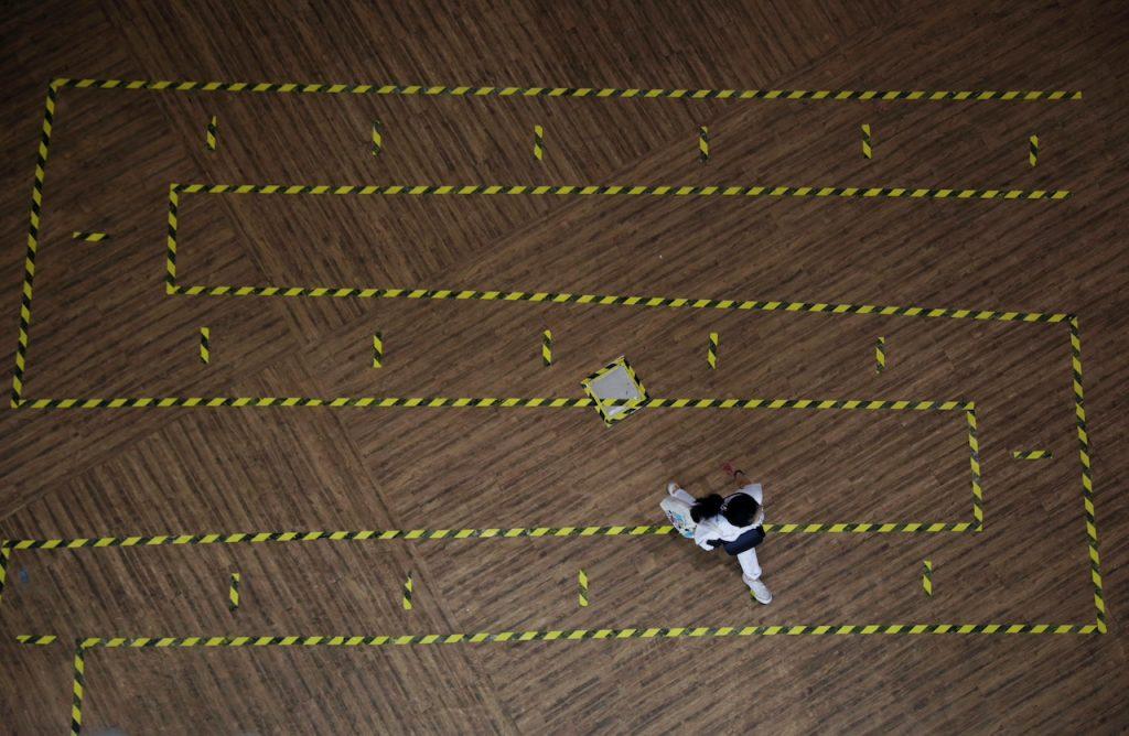 A woman walks across a line of tape demarcating social distancing in a mall in Singapore, Sept 28, 2021. Photo: Reuters