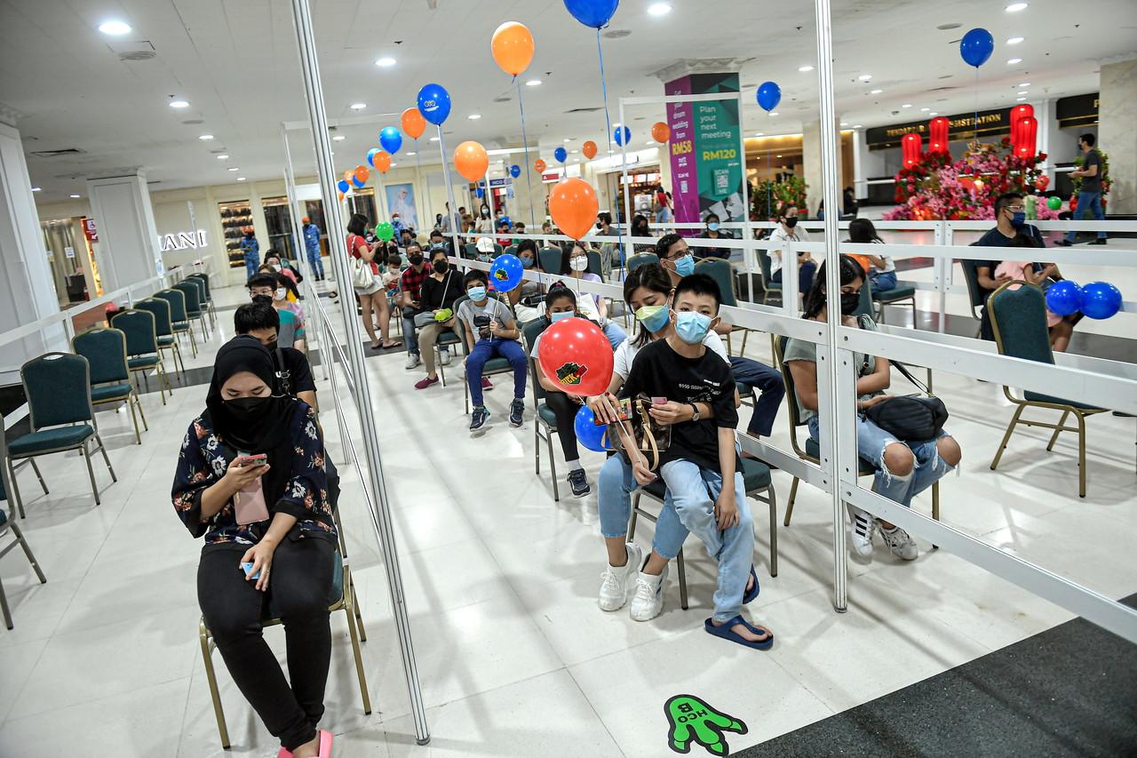 Parents and guardians wait with their children on the first day of the National Covid-19 Immunisation Programme for Children or PICKids for those aged five to 11 at the World Trade Centre in Kuala Lumpur. Photo: Bernama