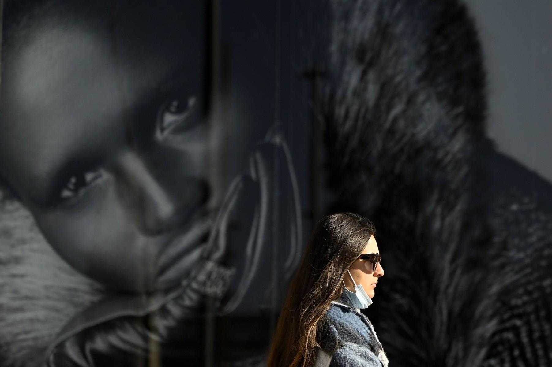A woman walks in the street without wearing her face mask in Madrid on Jan 27. Photo: AFP