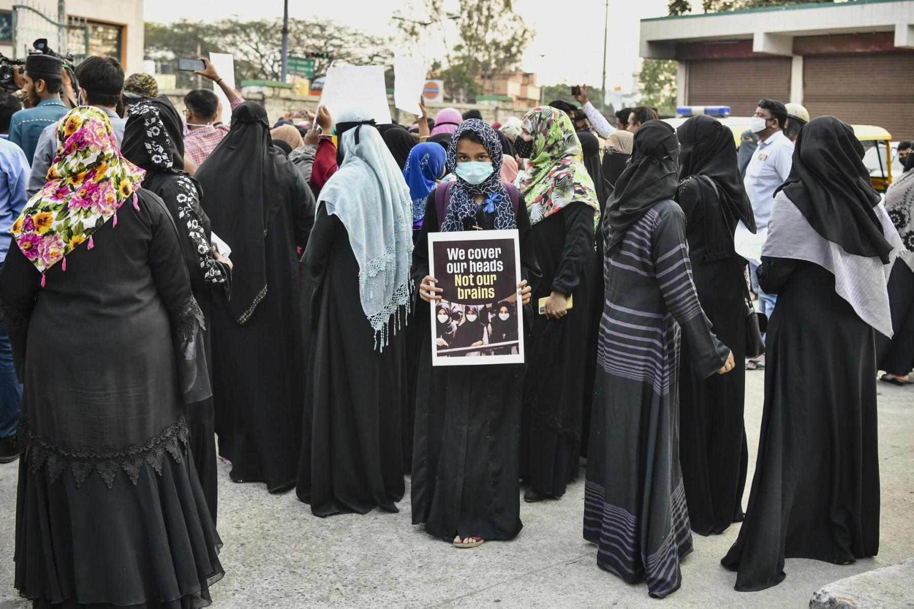 Muslim women hold placards during a demonstration after educational institutes in Karnataka denied entry to students for wearing hijabs, in Bangalore on Feb 7. Photo: AFP