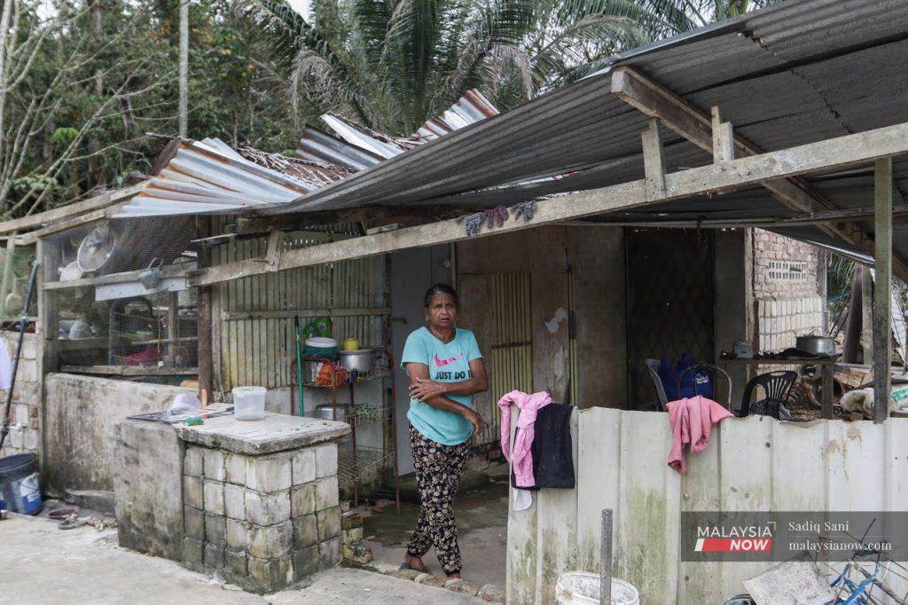M Dewi berdiri di luar gerai beliau di Telemong, Bentong di man ia rosak teruk akibat banjir di kawasan itu Disember tahun lalu.