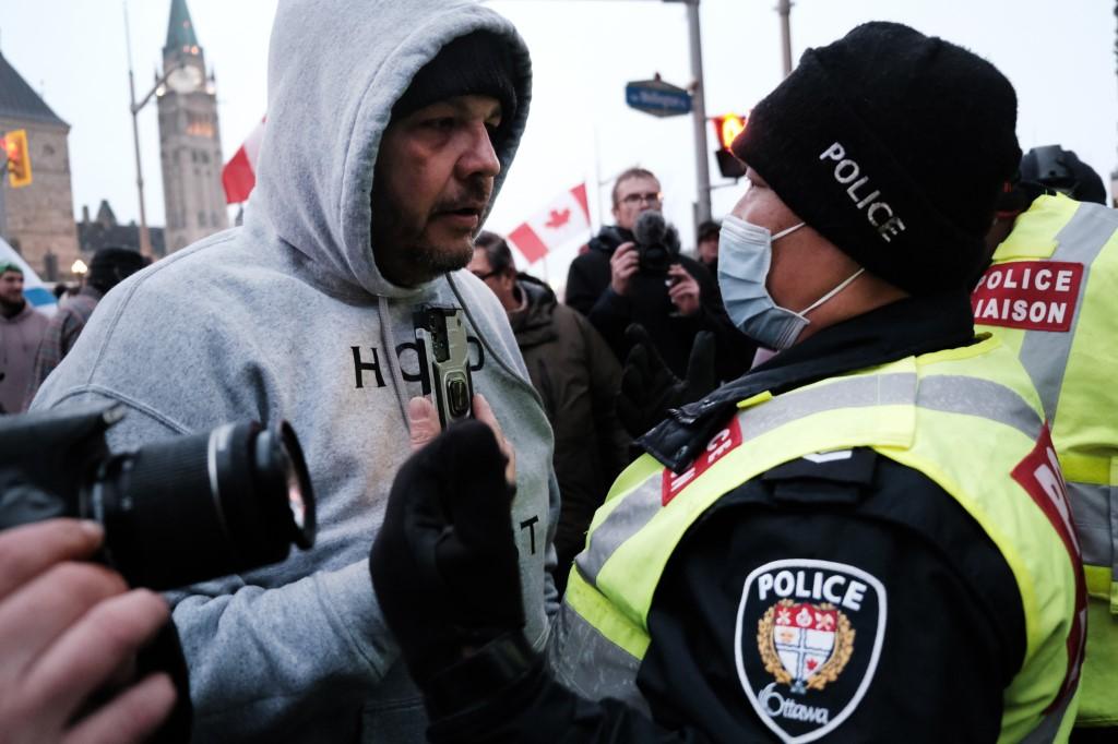 A member of a group supporting the trucker protests and a police officer argue as the group continues to gather and block the streets of downtown Ottawa as part of a convoy of truckers against Covid mandates in Canada on Feb 11 in Ottawa, Ontario, Canada. Photo: AFP