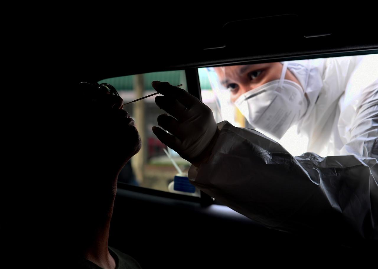 Seorang petugas kesihatan mengambil sampel bagi ujian saringan Covid-19 di Bangi. Gambar: Bernama