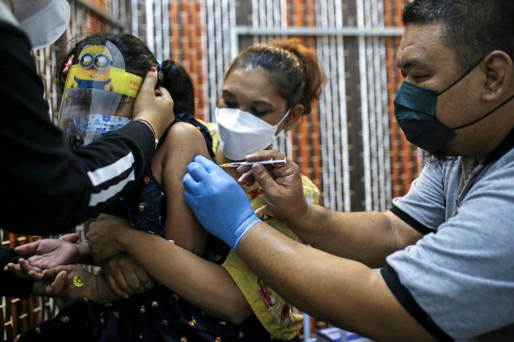 Seorang wanita memujuk anaknya ketika proses suntikan vaksinasi di bawah PICKids do Mesamall, Nilai. Gambar: Bernama