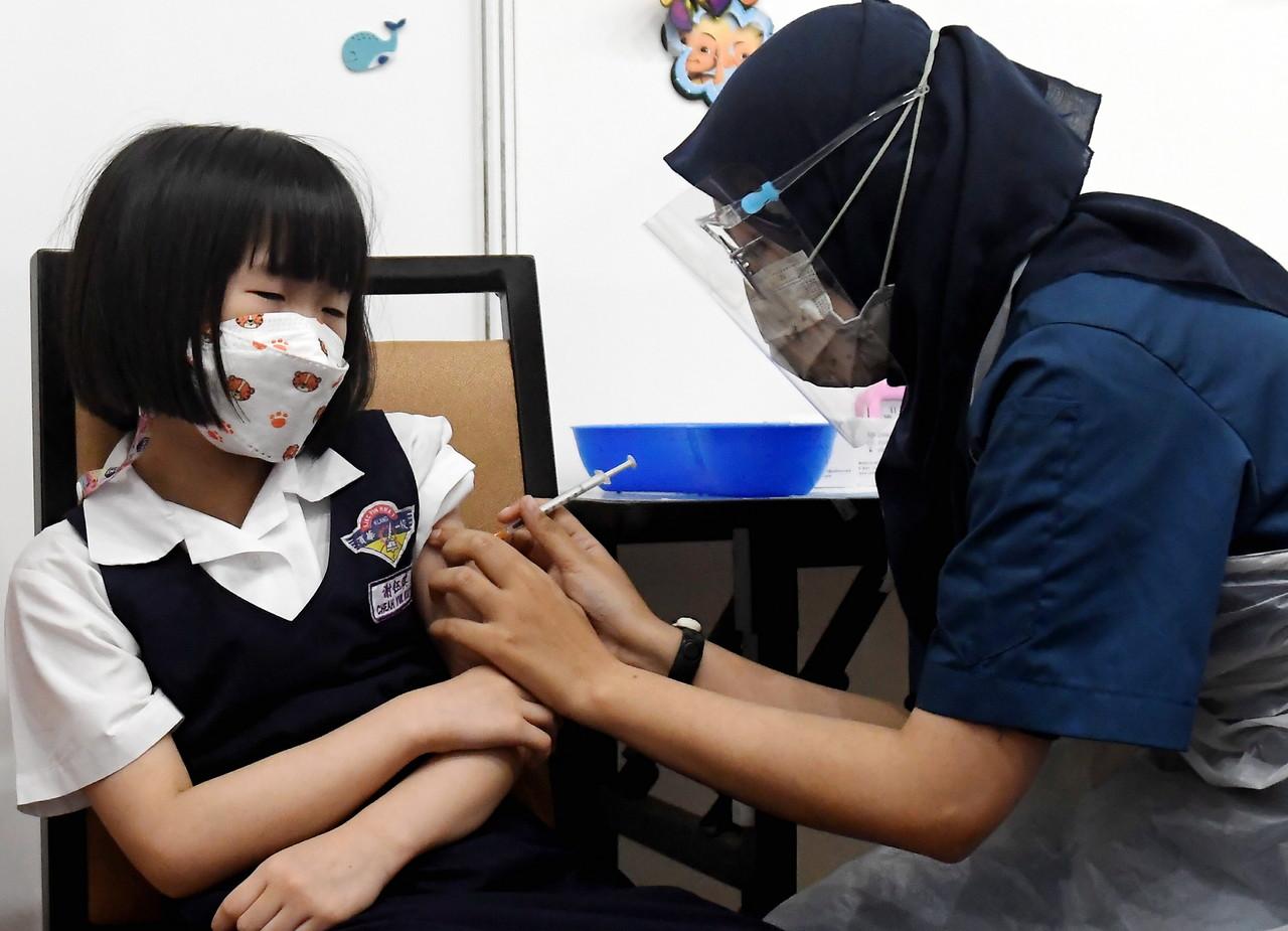 Petugas kesihatan memberi suntikan vaksin Covid-19 kepada kanak-kanak yang hadir pada Program Imunisasi Covid-19 Kanak-Kanak (PICKids) di PPV IDCC Seksyen 15, Shah Alam. Gambar: Bernama
