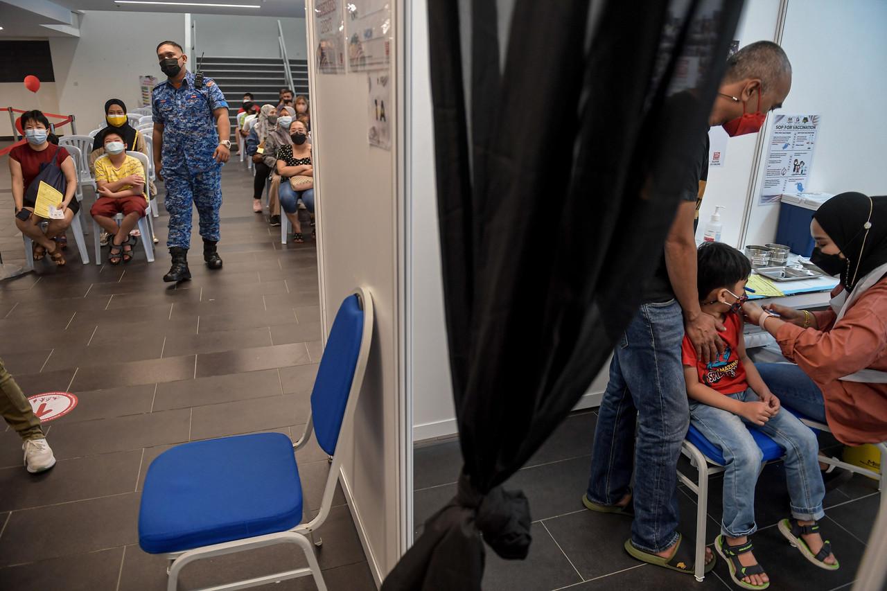 A nurse administers a shot of Covid-19 vaccine for children while others wait their turn at the Axiata Arena vaccination centre in Bukit Jalil, Kuala Lumpur. Photo: Bernama