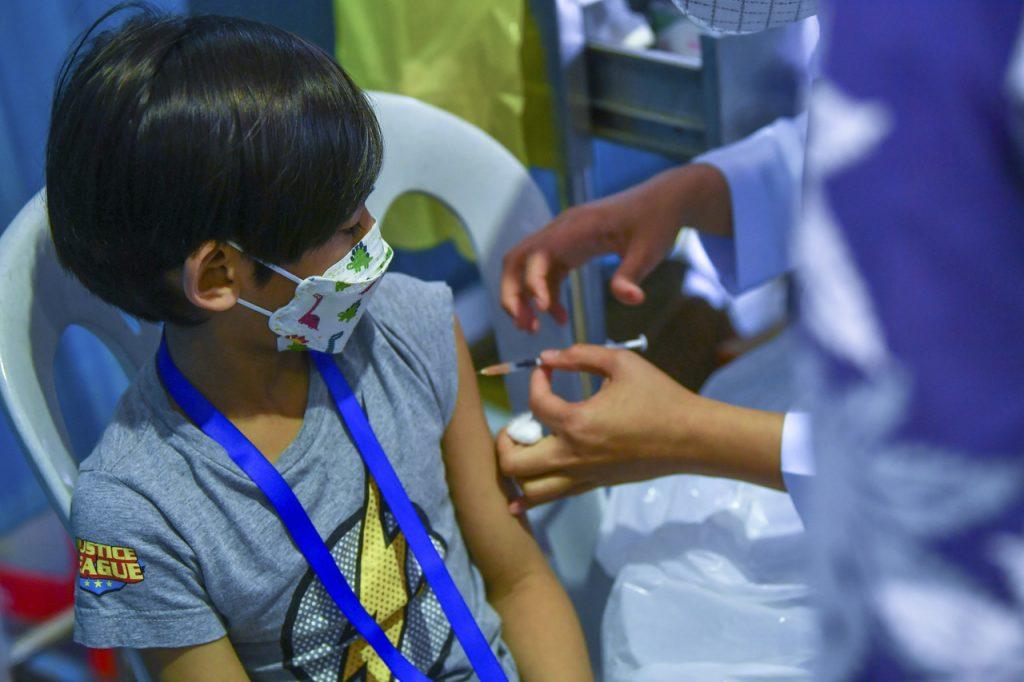 Seorang petugas kesihatan menjalankan vaksinasi kepada seorang kanak-kanak di SK Putrajaya Presint 11 (3). Gambar: Bernama
