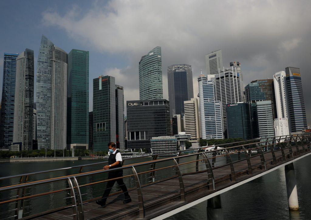 Seorang lelaki melintas jambatan di pusat bandar Singapura. Gambar: Reuters