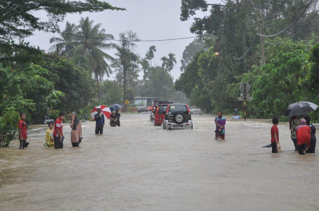 Mangsa banjir mengharungi arus banjir berdekatan Kampung Darau di Besut, Terengganu. Gambar: Bernama