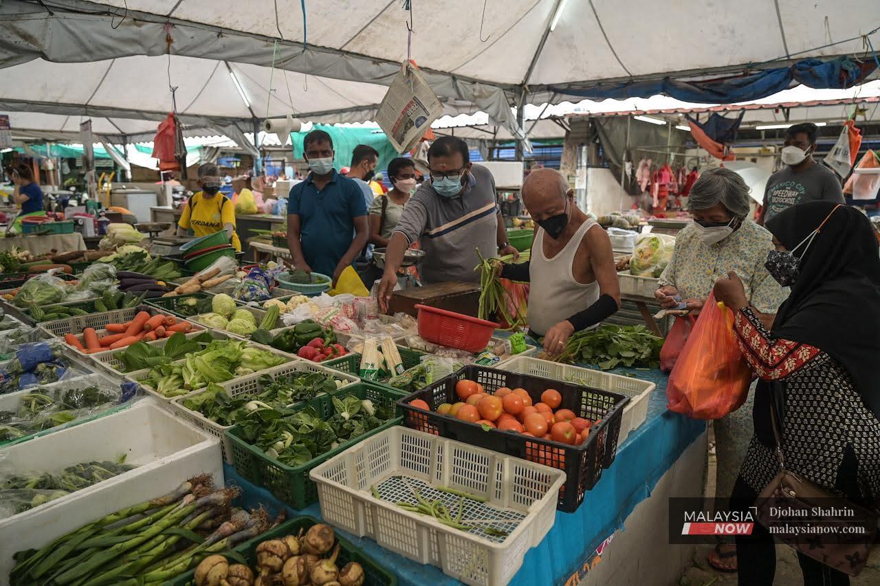 Pengunjung pasar Ampang di Kuala Lumpur memakai pelitup muka bagi melindungi diri daripada wabak Covid-19.