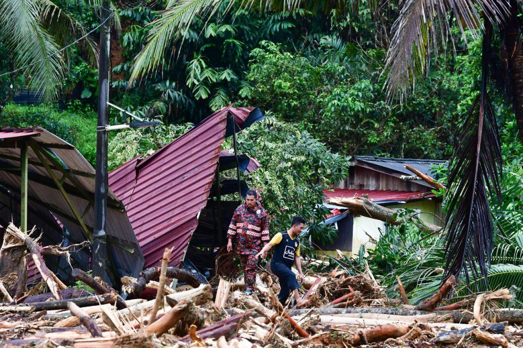 Pegawai penyelamat dan bomba meninjau kerosakan rumah akibat pokok yang tumbang selepas hujan lebat di Kampung Belukar Bukit, Hulu Terengganu. Gambar: Bernama